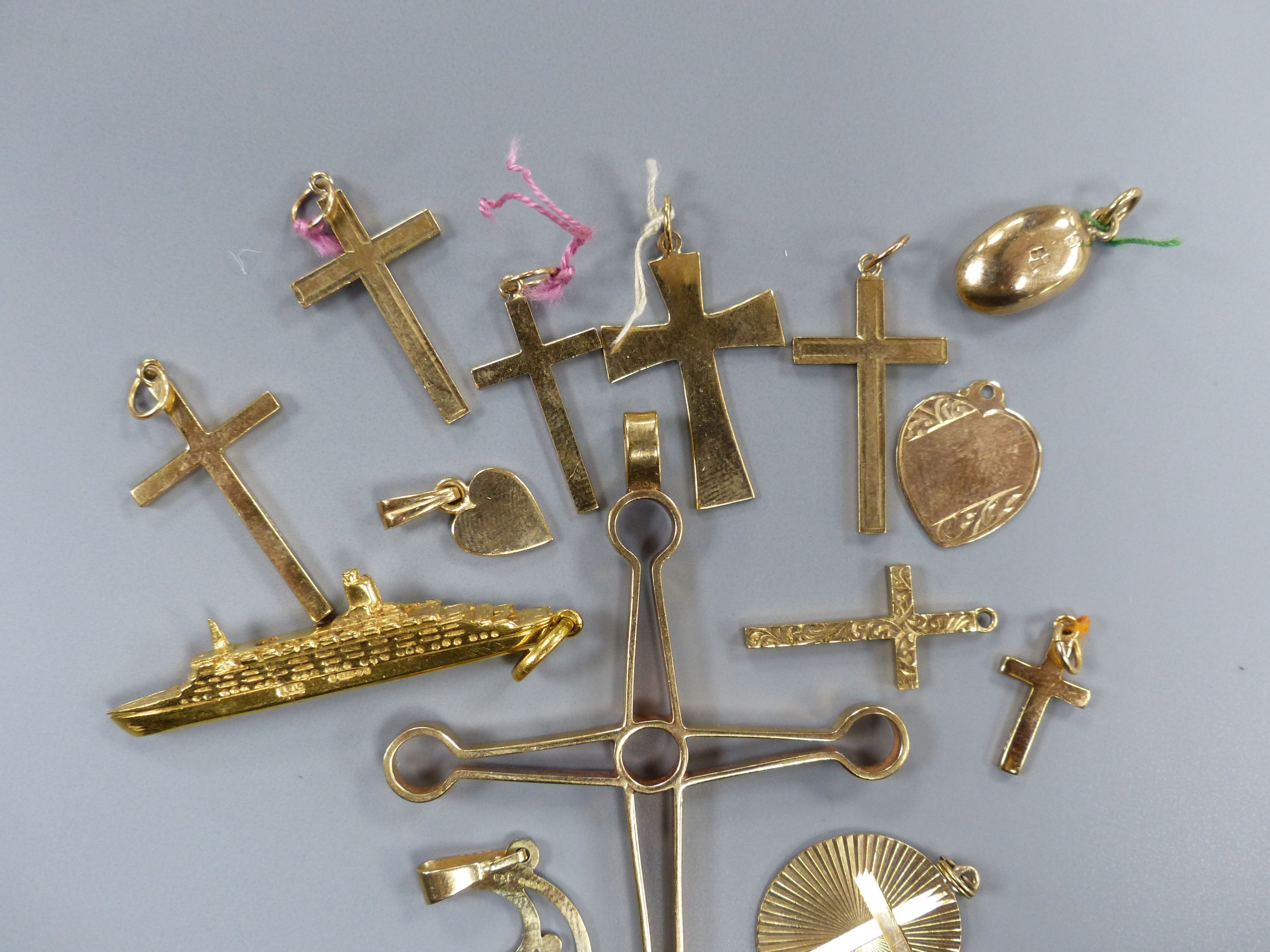 Fourteen assorted 9ct gold pendants including heart, QEII ship and crosses, largest 67mm,